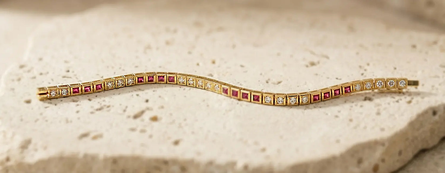 Gold bracelet with pave gemstones on a textured beige surface