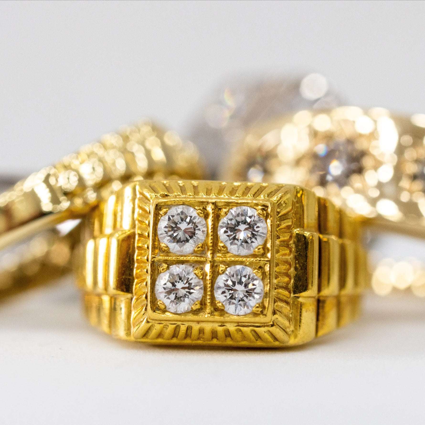 Gold ring with diamond accents on a light background